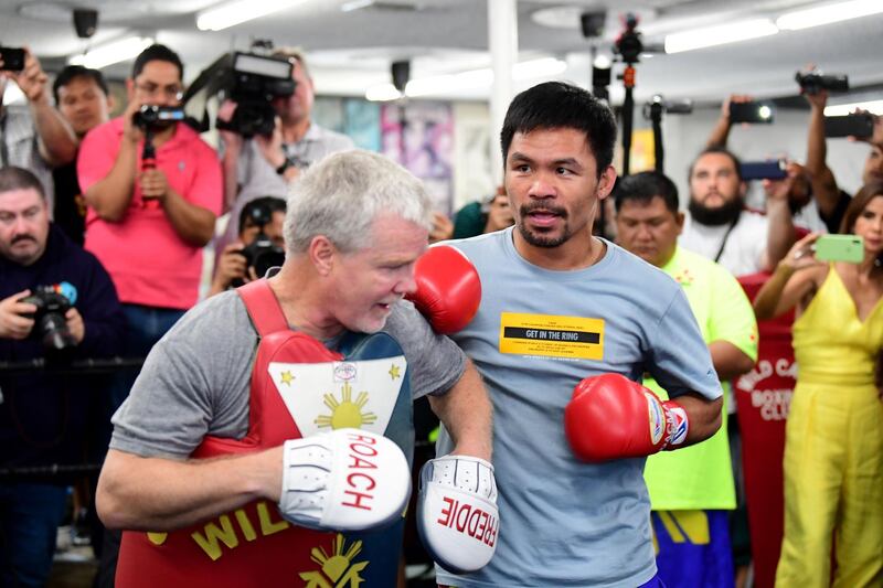 Journalists and fans gather around as eight-division world champion boxer Manny Pacquiao spars with coach Freddy Roach. AFP