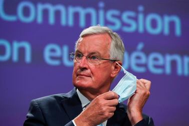 EU's Brexit negotiator Michel Barnier takes off his face mask as he holds a news conference after a meeting with Britain's chief negotiator in Brussels on August 21, 2020. / AFP 