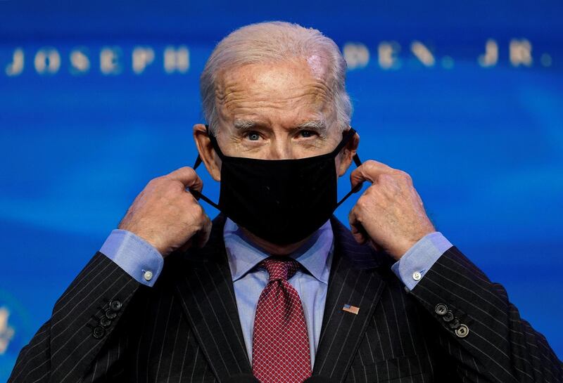US President-elect Joe Biden removes his mask as he announces members of economics and jobs team at his transition headquarters in Wilmington, Delaware, US. Reuters