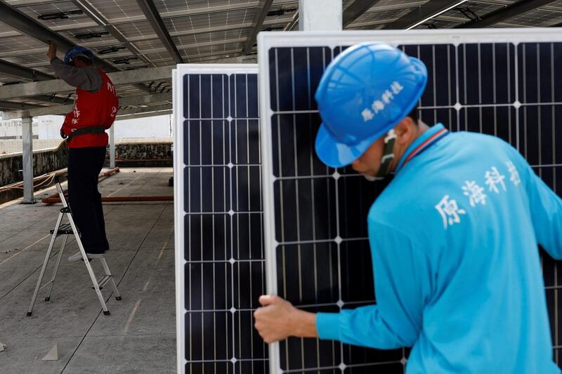 Asian countries make up 62 per cent of the renewables job force. Above, workers install solar panels in Taiwan. Tyrone Siu / Reuters