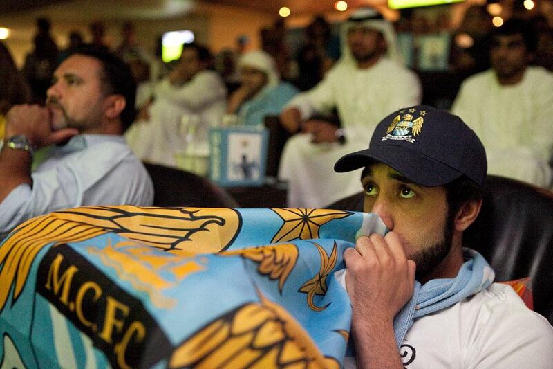 Othman Said Saif of Al Ain reacts to the action on a TV screen as he and about hundred other fans gather to watch the Manchester United v Manchester City game at the Clubhouse at the Zayed Sports City in Abu Dhabi.  Silvia Razgova / The National