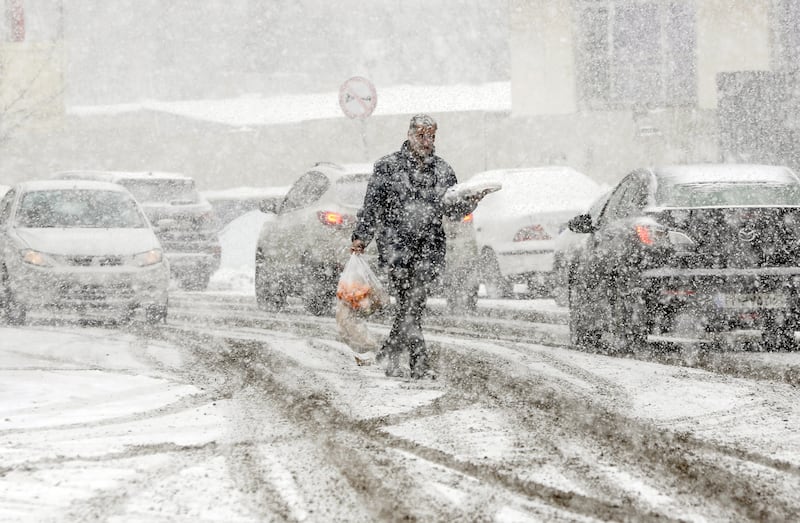 A man carries shopping through heavy snowfall in Tehran. Irna news agency urged consumers to be careful about their energy use as shortages threaten Iran because of the cold weather. EPA