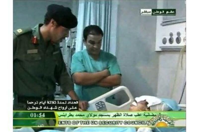 Libyan state television yesterday broadcast images of a man it said is Khamis Qaddafi, left, visiting victims of a Nato air strike in Tripoli.