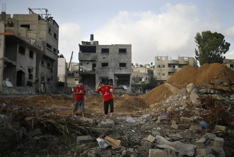 Two Palestinian men stand amidst the rubble of Tayseer Al-Batsh's family house, destroyed in an Israeli air strike in Gaza City (REUTERS/Mohammed Salem)