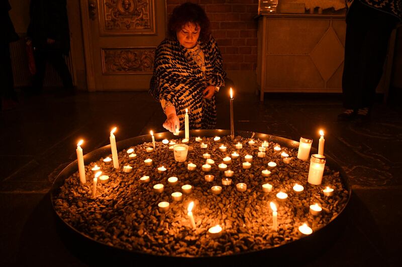 A mourner lights a candle at a memorial service for the victims of Ukrainian Airlines flight PS752 crash in Iran at Storkyrkan church in Stockholm on January 15, 2020. (Photo by Jonathan NACKSTRAND / AFP)