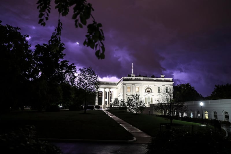 Lightning illuminates the clouds of a thunderstorm behind the White House in Washington, DC, USA.  EPA