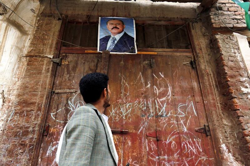 A Yemeni looks at a poster of Yemeni ex-president Ali Abdullah Saleh in the old city of Sana'a, Yemen. Yahya Arhab / EPA