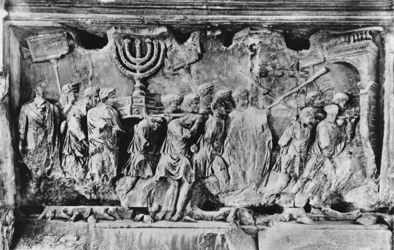 A relief from the Arch of Titus in Rome, photographed circa 1955. The carving depicts spoils, including the Menorah and the trumpets of Jericho, being carried away from the Temple after the Siege of Jerusalem in 70 AD. Getty