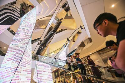 Shoppers ride on escalators at the EmQuartier shopping mall, operated by The Mall Group, during the mall's opening day in Bangkok, Thailand, on Friday, March 27, 2015. Thailand is scheduled to release consumer price index (CPI) data on April 1. Photographer: Dario Pignatelli/Bloomberg