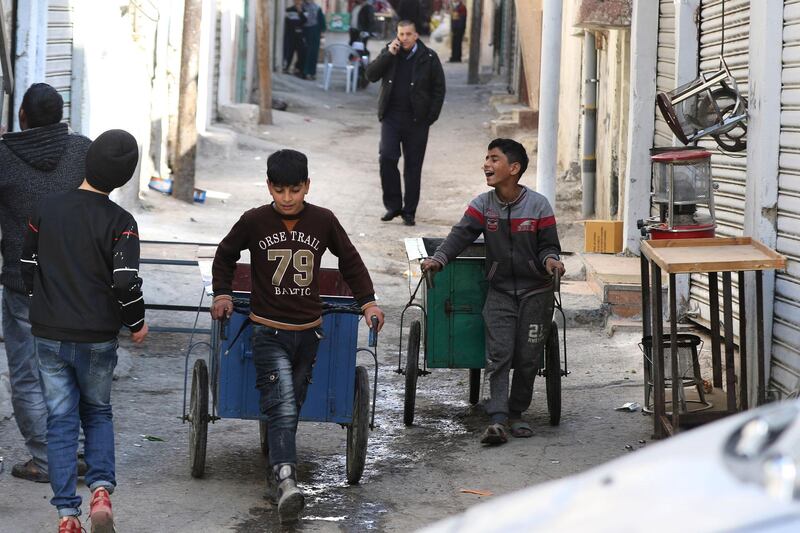 Children with handcarts working in the Wahdat district of Amman. Many schools in Jordan have been closed for almost a year due to the Covid-19 pandemic. AFP