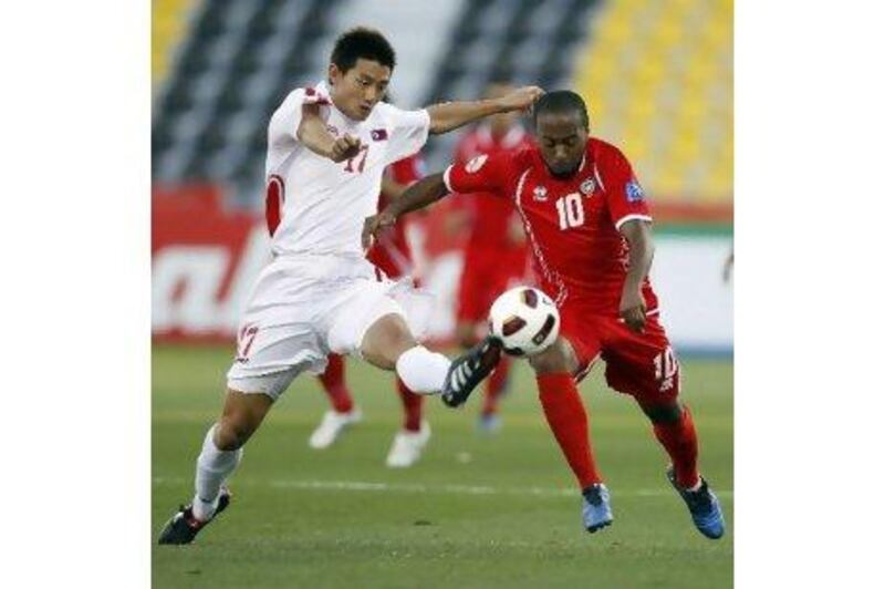 North Korea's An Yong-hak, left, struggles to take the ball from the UAE's Ismail Matar during last night's match. Hassan Ammar / AP Photo