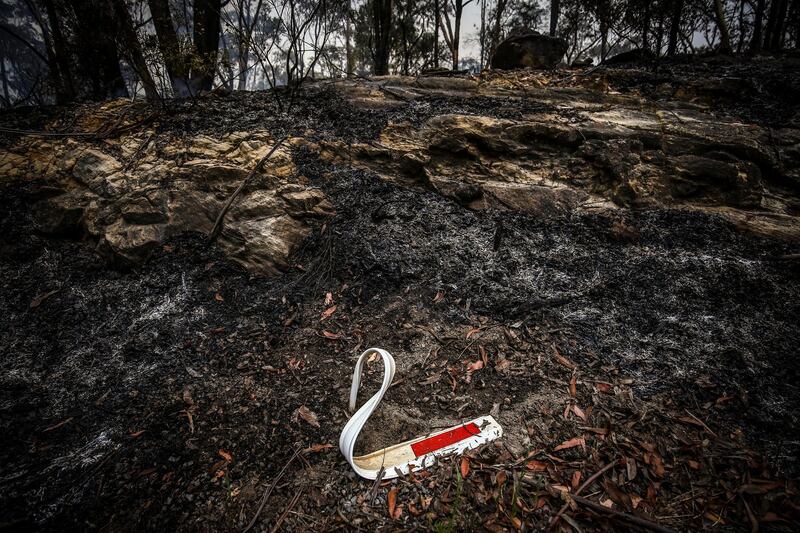 The remains of a melted road reflector sits in burned bushland during back-burning operations near the town of Kulnura, New South Wales, Australia. Bloomberg