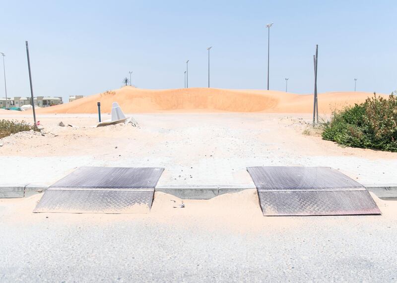 DUBAI, UNITED ARAB EMIRATES - JULY 15 2019.

Residents use unpaved roads to access their villas at Living Legends.

Some residents and investors of Living Legends have paid Dh6m for villas, and pay Dh25,000 a year in service charges but the development still looks like a construction site, with an unfinished golf course, roads, open sewer works near the school, poor lighting and no desert boundary meaning dangerous snakes and animals are regularly getting into the gardens and villas. 

(Photo by Reem Mohammed/The National)

Reporter: NICK WEBSTER
Section: NA