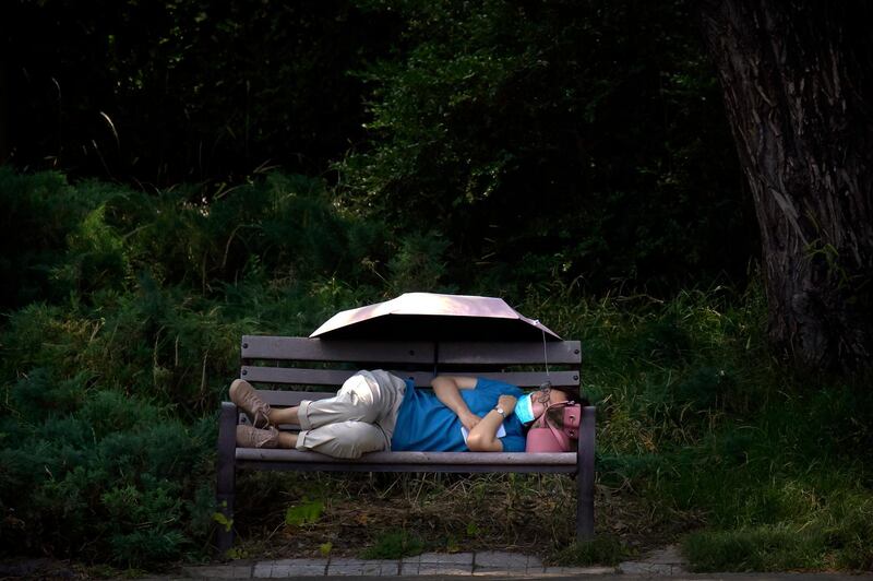 A woman wearing a face mask rests on a bench at a public park in Beijing amid easing of restrictions enforced to prevent the spread of the coronavirus. AP Photo