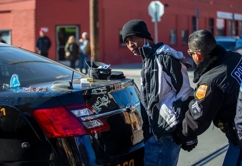 An El Paso police officer pats down a Venezuelan migrant after his arrest at the camping site outside the Sacred Heart Church in downtown El Paso, Texas in Sunday. AP