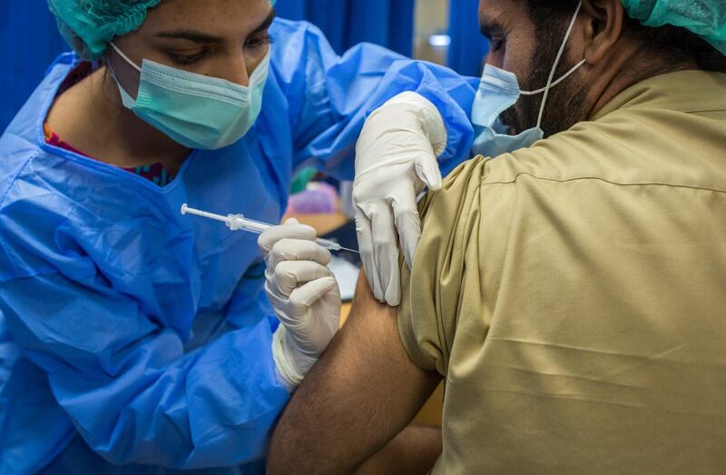 A health worker administers a dose of the Sinopharm Group Co. Covid-19 vaccine to a colleague in the Adult Vaccination Center at the Dow University Hospital in Karachi, Pakistan, on Wednesday, Feb. 3, 2021. Pakistan has granted approval to Russia's Sputnik V vaccine according to people familiar with the matter. The South Asian country has already ordered 1.2 million doses from Chinese state-backed vaccine developer Sinopharm, and has also given approval to AstraZeneca Plcs shot for private use. Photographer: Asim Hafeez/Bloomberg