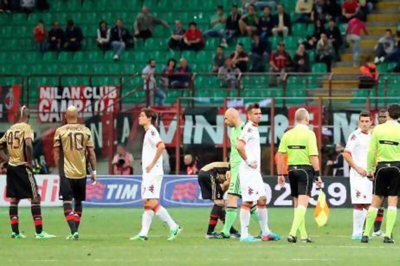 AC Milan players Mario Balotelli, left, and Kevin Prince Boateng with other teammates and Roma players wait for racist chants to stop. Antonio Calanni / AP Photo