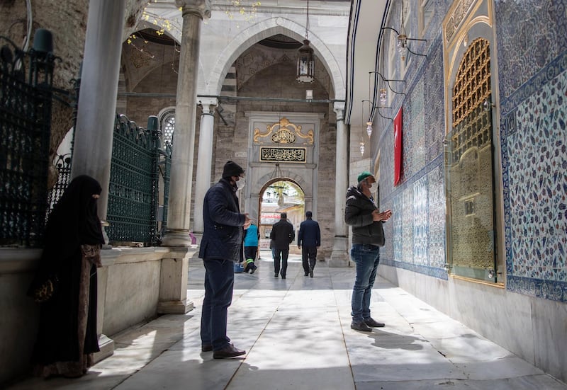 People wearing protective face masks pray at the courtyard of the Eyup Sultan Mosque for the upcoming Ramadan, in Istanbul, Turkey.  EPA