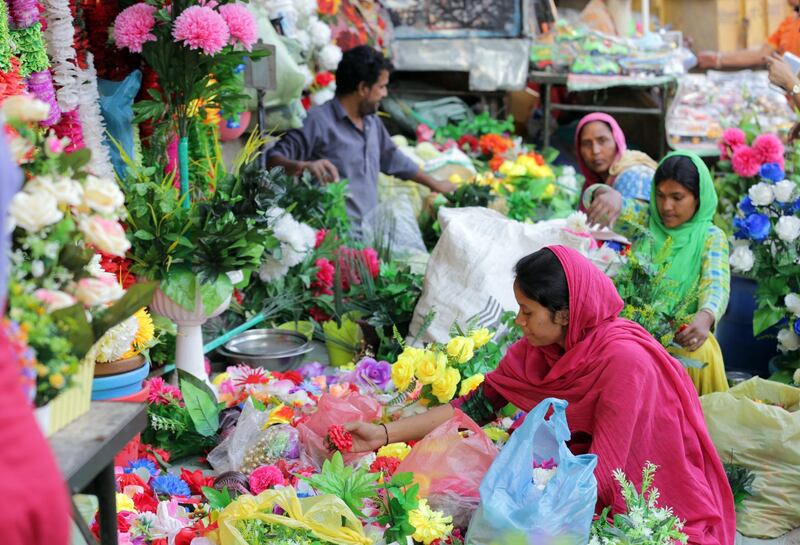 Indian vendors prepare artificial flower pots for sale at a roadside shop on the eve of Diwali festival in Amritsar, India. EPA