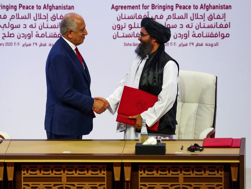 FILE PHOTO: Mullah Abdul Ghani Baradar, the leader of the Taliban delegation, and Zalmay Khalilzad, U.S. envoy for peace in Afghanistan, shake hands after signing an agreement at a ceremony between members of Afghanistan's Taliban and the U.S. in Doha, Qatar February 29, 2020. REUTERS/Ibraheem al Omari/File Photo