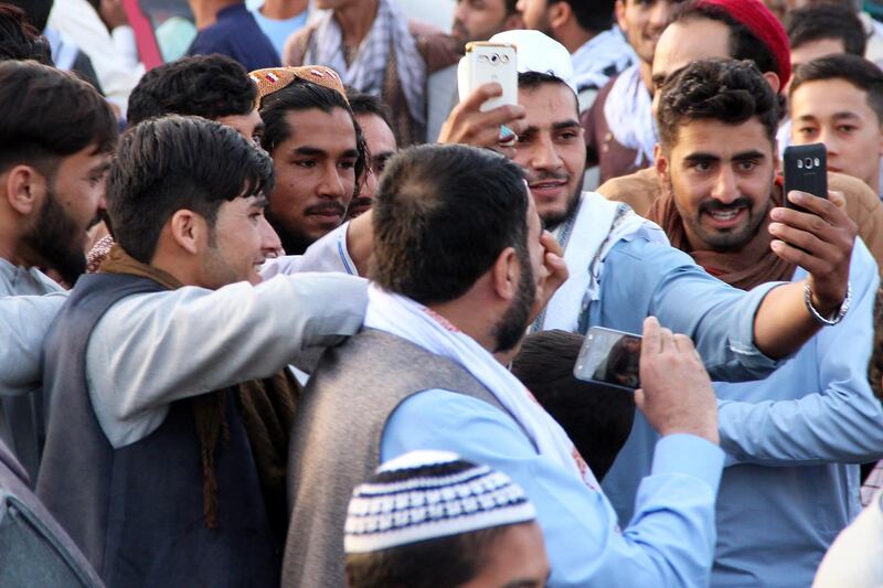 epa06811255 People take a selfie with an alleged Taliban militant as a group of Taliban visit a bazaar to greet people as a goodwill gesture amid a three-day ceasefire on first day of Eid al-Fitr, in Kunduz, Afghanistan, 15 June 2018. Earlier in the month, President Ghani's government had announced a temporary ceasefire, starting on Jun. 12, to last until the end of the festival. The Taliban had followed suit a few days later and announced a three-day partial ceasefire during the festival. Muslims around the world are celebrating Eid al-Fitr, the three day festival marking the end of the Muslim holy month of Ramadan. In most countries it is observed on 15th of June while others will observe it on the 16th of June depending on the lunar calendar. Eid al-Fitr is one of the two major holidays in Islam.  EPA/STRINGER