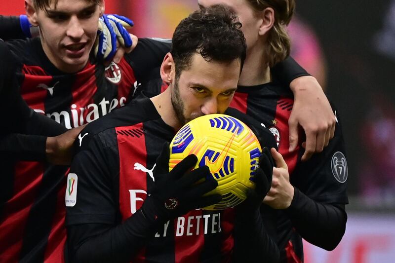 AC Milan's Turkish midfielder Hakan Calhanoglu kisses the ball after he scored the winning penalty in the penalty shootout during the Italian Cup (Coppa Italia) round of sixteen football match AC Milan vs Torino on January 12, 2021 at the San Siro stadium in Milan. / AFP / MIGUEL MEDINA
