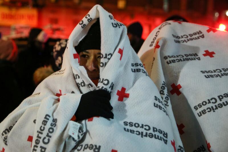 Evacuees wear blankets as they stand outside the apartment building that caught fire in New York's Bronx district on December 28, 2017. Amr Alfiky / Reuters