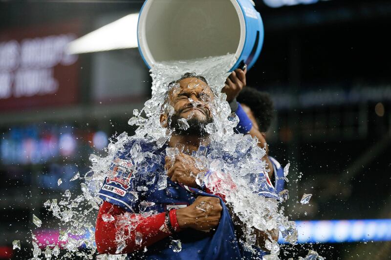 Texas Rangers' Delino DeShields receives an ice water shower from  Elvis Andrus after hitting a game-winning RBI single in the 12th inning of the team's baseball game against the Baltimore Orioles. AP