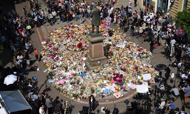 People gather to see flowers and messages of support left around a statue of Richard Cobden in St Ann's Square in Manchester, northwest England on May 25, 2017, placed in tribute to the victims of the May 22 terror attack at the Manchester Arena.
Police said they arrested two men Thursday in the Manchester area in connection with the deadly bombing of an Ariana Grande pop concert, while a detained woman was released without charges. Britain has raised its terror alert to the maximum level and ordered troops to protect strategic sites after 22 people were killed in a suicide bomb attack on a Manchester pop concert. / AFP PHOTO / Oli SCARFF