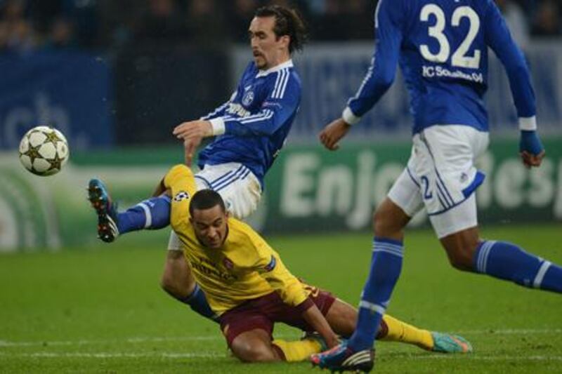 Schalke's Christian Fuchs clashes with Arsenal's Theo Walcott