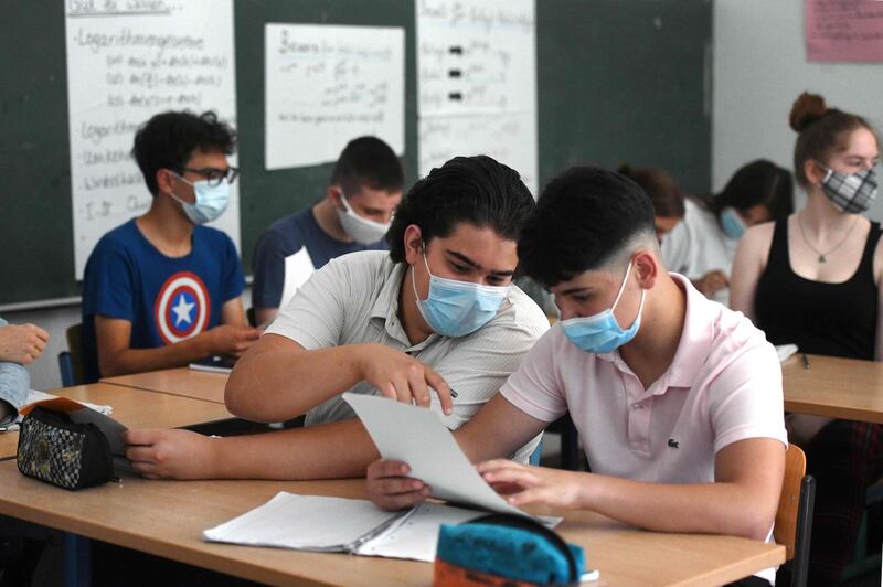 Students of the eleventh grade sit with face masks in a classroom of the Phoenix high school in Dortmund, western Germany, on August 12, 2020, amid the novel coronavirus COVID-19 pandemic. Schools in the western federal state of North Rhine-Westphalia re-started under strict health guidelines after the summer holidays. / AFP / Ina FASSBENDER
