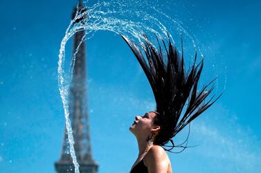 A woman plays the water as she cool herself down in the fountain of the Trocadero esplanade in Paris on June 25, 2019 with the Eiffel Tower on the background. Forecasters say Europeans will feel sizzling heat this week with temperatures soaring as high as 40 degrees Celsius in an “unprecedented" June heatwave hitting much of Western Europe. AFP 