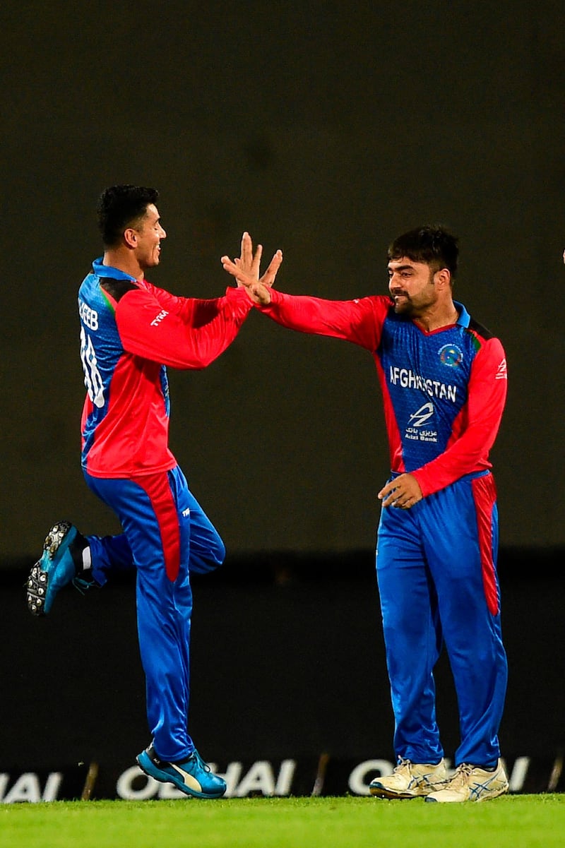 Afghanistan's Mujeeb Ur Rahman (L) celebrates with captain Rashid Khan (R) after the dismissal of Bangladesh's captain Shakib Al Hasan during the third match between Afghanistan and Bangladesh in the T20 Tri-nations cricket series at the Sher-e-Bangla National Stadium in Dhaka on September 15, 2019. / AFP / MUNIR UZ ZAMAN

