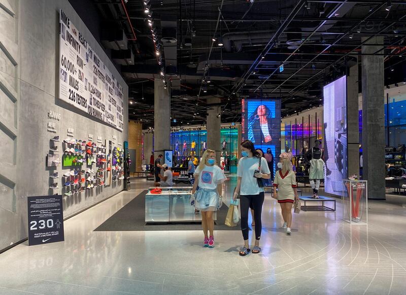 People wearing protective face masks and gloves shop at Dubai Mall on May 3, 2020. Reuters