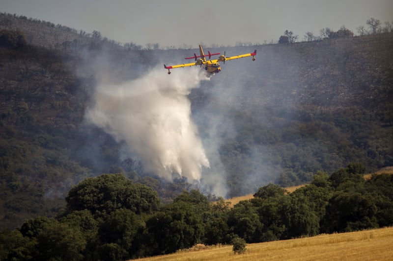A firefighting aircraft drops water on a forest fire in Malagon, Spain. EPA