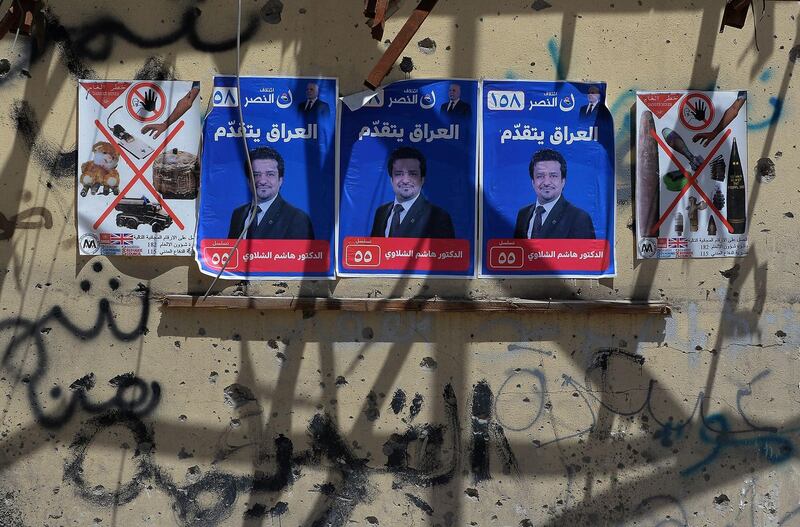 Election campaign posters are seen plastered on the wall of a destroyed building in the former embattled city of Mosul on May 1, 2018 ahead of the upcoming Iraqi parliamentary elections.  / AFP PHOTO / Zaid AL-OBEIDI