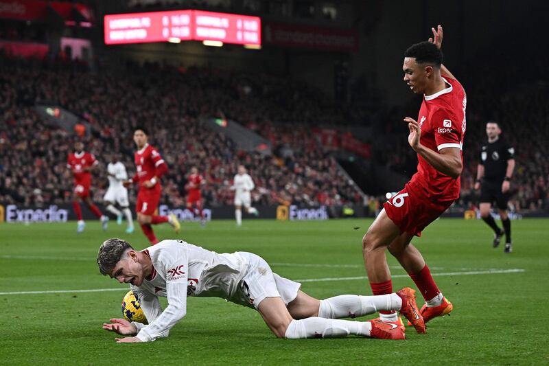Manchester United's Alejandro Garnacho goes down after a challenge by Liverpool's Trent Alexander-Arnold. AFP