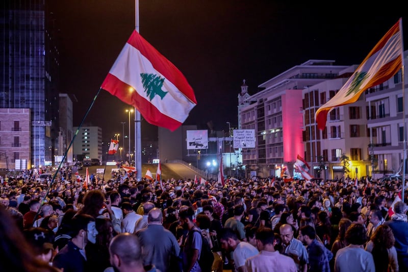 Protesters wave Lebanese flags shout slogans as they block the Ring Bridge highway during a protest in Beirut.  EPA