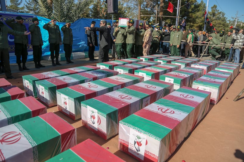 Iranian mourners gather round coffins of victims of the bombings in Kerman at their funerals. Getty Images