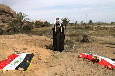 An Iraqi man prays for his slain relative, at the site of a mass grave, believed to contain the bodies of Iraqi soldiers killed by ISIS when they overran Camp Speicher military base, in Tikrit, Iraq. AP 
