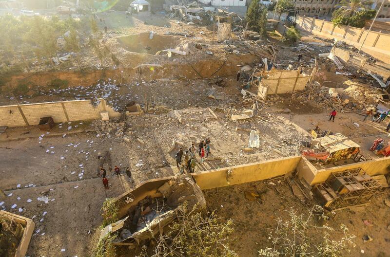 Palestinians look at the damage at a Hamas military facility early on December 9. Mahmud Hams / AFP Photo.