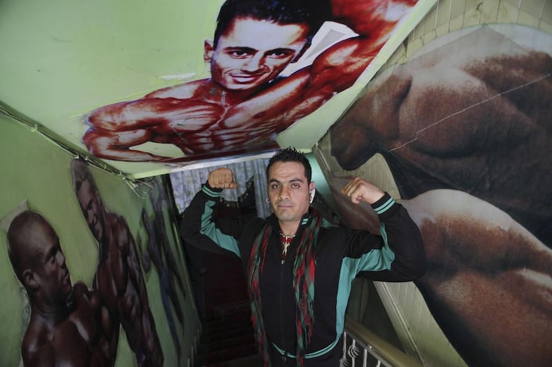 The owner of a bodybuilding club flexes his muscles.