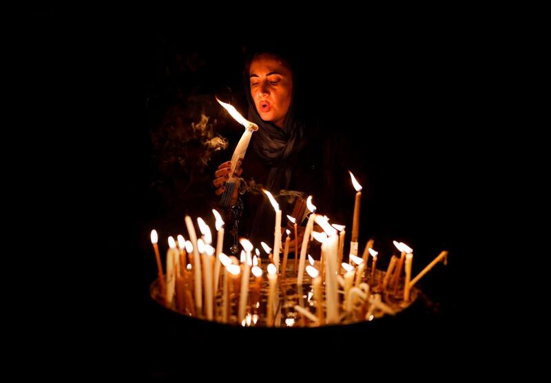 A woman blows on candles inside the Church of the Holy Sepulchre in the Old City of Jerusalem. AFP