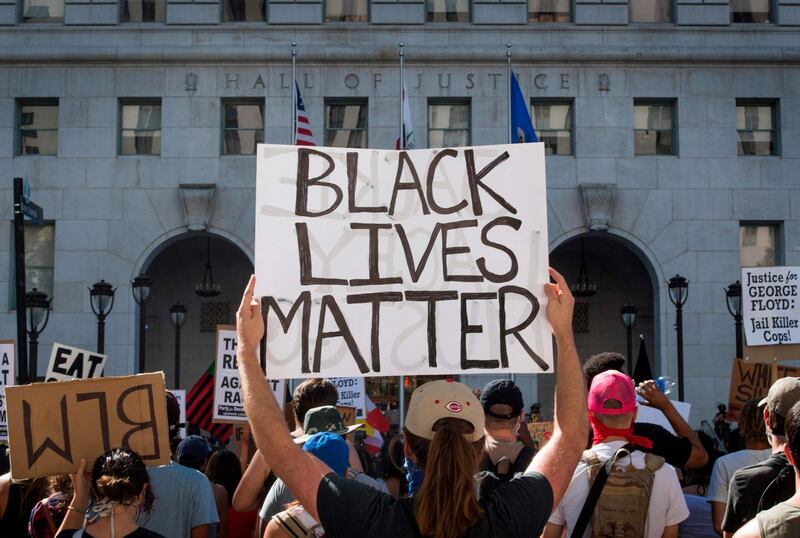 Supporters of Black Lives Matter, hold signs during a protest outside the Hall of Justice in Los Angeles, California.  AFP
