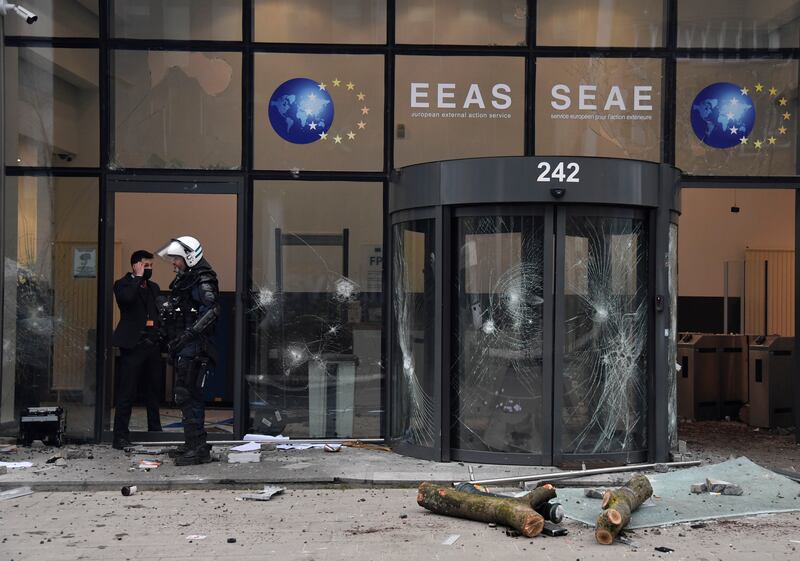 A police officer walks into an EU building damaged during the clashes. AP