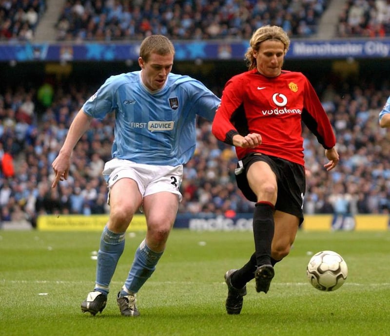 Manchester United's Diego Forlan, right, is challenged by Manchester City's Richard Dunne during a Premier League match at The City of Manchester Stadium in Manchester on March 14, 2004. Paul Barker / AFP