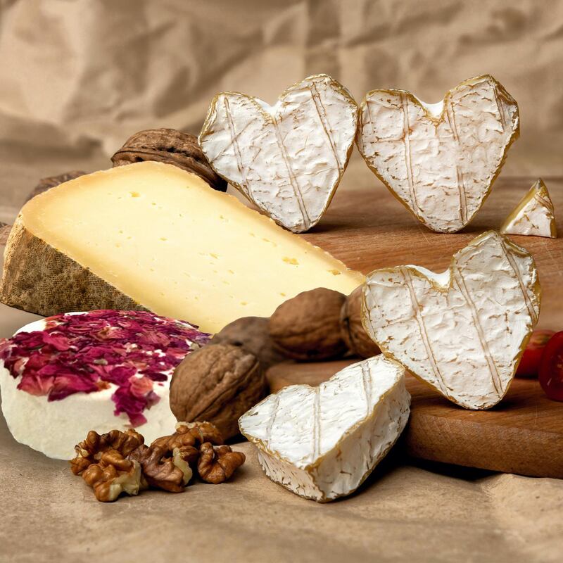 Neufchatel, French cheese made in Normandy from cow's milk. with walnut kernels and cherry tomatoes on a wooden wooden background. Copy space white mold growing