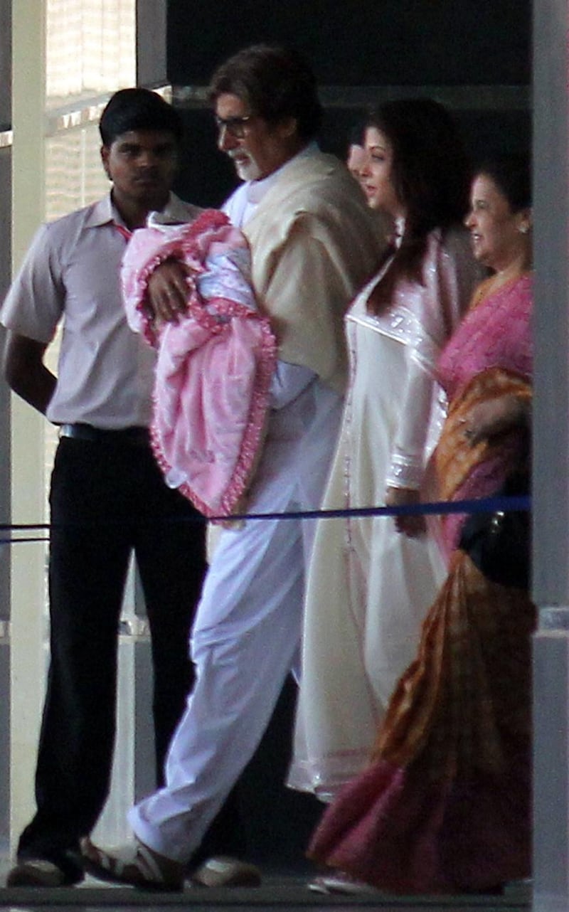 epa03011901 Bollywood actor Amitabh Bachchan (2-L) walks out of a hospital holding his grand-daughter along with his daughter-in-law Aishwarya Rai Bachchan (2-R), in Mumbai, India, 22 November 2011. Former Miss World and Bollywood actress Aishwarya Rai Bachchan, wife of Amitabh Bachchan's son, delivered the baby girl on 16 November 2011.  EPA/STR