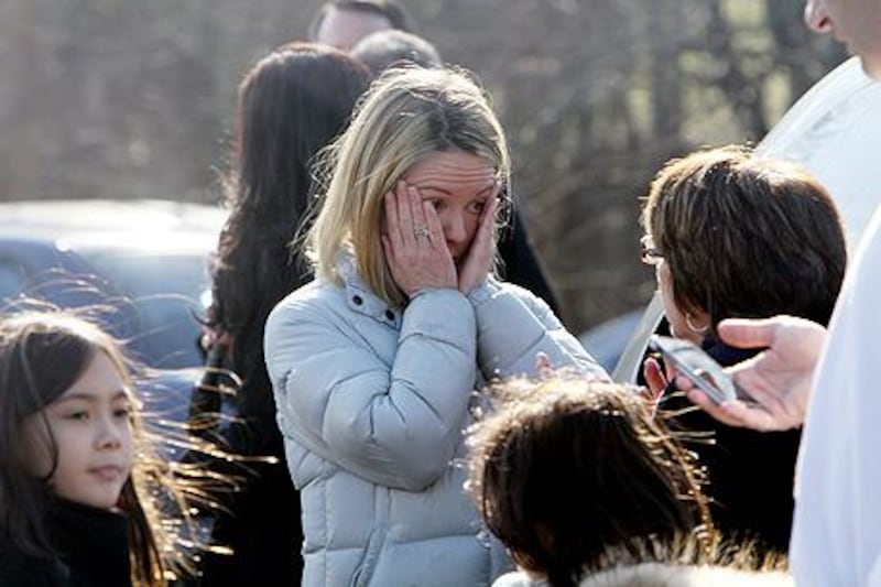 A woman weeps as she arrives to pick up her children. AP