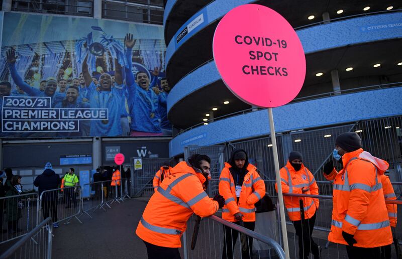 Stewards wait to check fans' NHS Covid-19 passes or proof of a negative test result, as they arrive to watch the English Premier League football match between Manchester City and Chelsea at the Etihad Stadium in Manchester. AFP